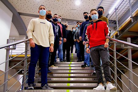Angehende Industriemeister stehen auf der Treppe im Foyer der SIHK Akademie in Hagen.