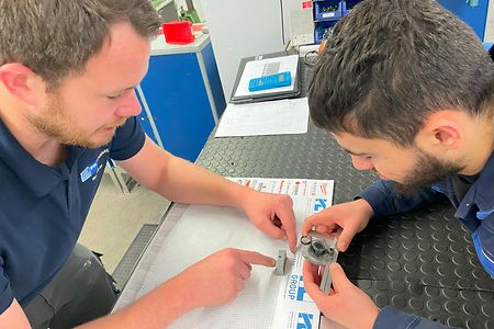 Metall-Ausbilder der SIHK Akademie arbeitet mit einem Teilnehmer eines Kurses intensiv am Lehrstoff.