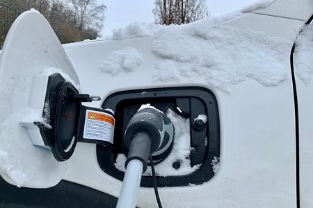 Ein Elektroauto hängt am Ladekabel.